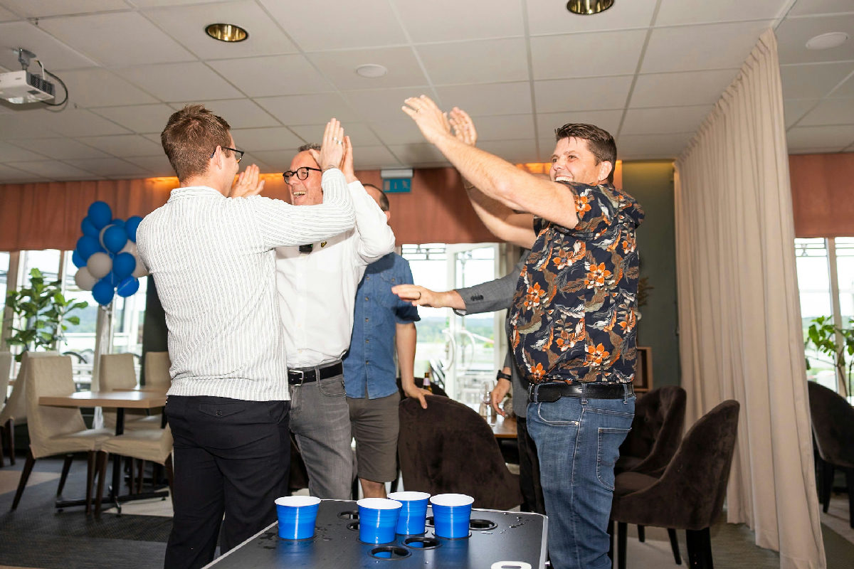 Bild på glada kollegor som kör beer-pong på konferens